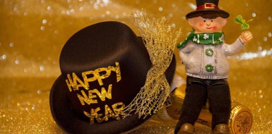 Un pupazzetto accanto a un cappello con scritto "Happy new year"