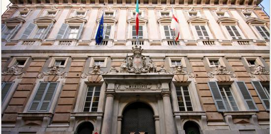 La facciata di Palazzo Tursi al di sopra del portone d&#039;ingresso con tre bandiere: Europa, Italia, Genova