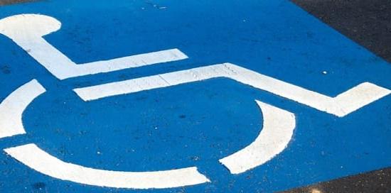 simbolo blu parcheggio disabili su asfalto