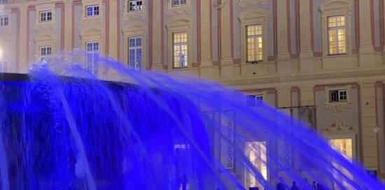 Una porzione della fontana illuminata di blu: sullo sfondo Palazzo Ducale (foto di repertorio)