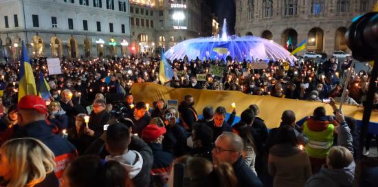 piazza De Ferrari con gente e fontana illuminata di giallo e blu