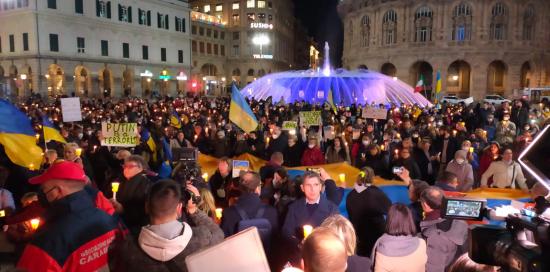 piazza De Ferrari con gente e fontana illuminata di giallo e blu