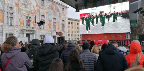 persone di spalle e maxischermo