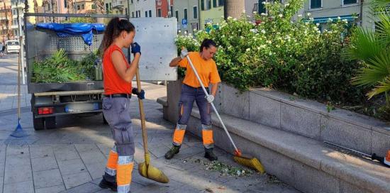 Due giardiniere di Aster al lavoro su una aiuola della passeggiata