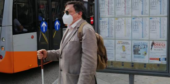 Una persona non vedente alla fermata del bus