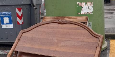 La testata di un letto appoggiata accanto a una campana del vetro