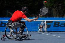 Un tennista in carrozzina fotografato di spalle