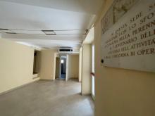 Foto del corridoio interno di vico Vegetti, in primo piano una porzione della targa a ricordo della SOMS Lavoratori del Legno