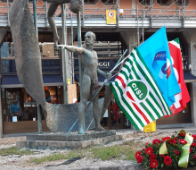 bandiere dei sindacati sullo sfondo della statua di guido rossa