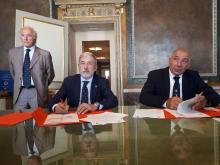 Il sindaco al tavolo mentre firma l'accordo