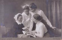 foto di un gruppo d quattro donne che guardano un libro