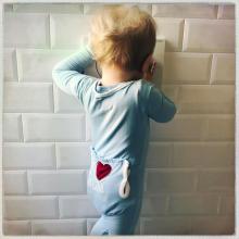 Da zero a mille Foto di bambino piccolo poggiato a un muro mentre gioca