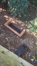 Un grosso divano, sedie ed altri rifiuti scaricati dalla strada in una area verde Un grosso divano, sedie ed altri rifiuti scaricati dalla strada in una area verde