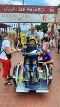 Un bimbo disabile sulla bici speciale attrezzata per il trasporto delle persone in carrozzina