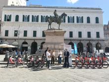 L'assessore Robotti sotto la statua di Garibaldi a cavallo, in largo Pertini, accanto ad alcune bici elettriche in sharing
