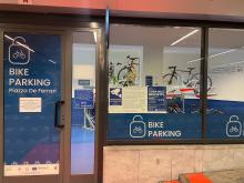 Foto a campo largo dell'ingresso del Bike Parking: insegna e "vetrina" con dentro le prime bici parcheggiate