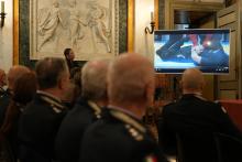 Gli agenti in platea guardano un video trasmesso sullo schermo del Salone