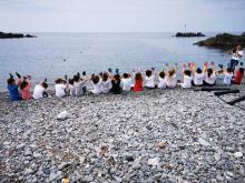 Bimbi sulla spiaggia a braccia alzate in segno di vittoria dopo una raccolta di piccoli rifiuti - foto di repertorio