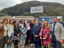 Gruppo con autorità davanti alla nuova targa