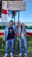 Marco Scarponi e Luca Rinaldi, fratello di Michele Scarponi e figlio di Rocco Rinaldi, abbracciati sotto la targa inaugurata