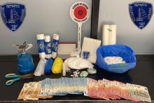 banconote, stupefacenti e altri oggetti sequestrati esposti su di un tavolo