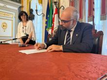 L'assessore Montanari firma lo schema di protocollo d'intesa. Sullo sfondo la Disability Manager del Comune Cristina Bellingeri