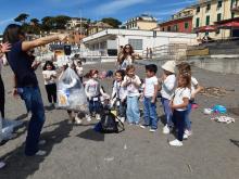 animatrice mostra il sacco con i rifiuti raccolti in spiaggia