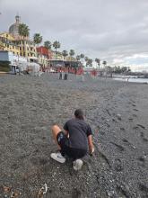 Una ragazza intenta a raccogliere mozziconi sulla spiaggia