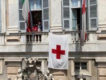 la bandiera della Croce rossa esposta sulla facciata di palazzo Tursi