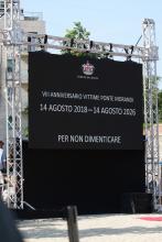 Lo schermo con la scritta "14 agosto 2018-14 agosto 2026: per non dimenticare"