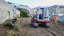 Una "ruspetta" impegnata nei lavori di sgombero della vegetazione arbustiva insistente sull'area. Al suo fianco un operaio.