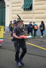 Un Alpino sfila tenendo tra le mani un cuscinetto tricolore con sopra un antico cappello "alpino"