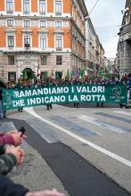 Alpini sfilano dietro allo striscione "Tramandiamo i valori che indicano la rotta"