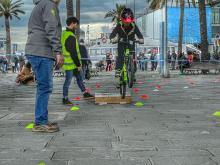 bambino supera ostacolo in bici al porto antico sotto la guida di un istruttore