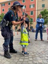 agente di polizia guida un bimbo nell'uso della paletta