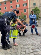 agente di polizia guida un bimbo nell'uso della paletta