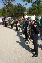 Carabinieri e agenti della Polizia Locale schierati a fianco delle corone commemorative