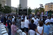 Un momento della commemorazione: il pubblico in piedi per onorare le 43 vittime