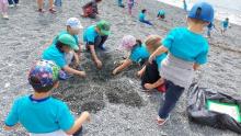 Bimbe e bimbi a "caccia" di rifiuti nella sabbia della spiaggia