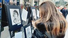 Una visitatrice della mostra fotografa uno dei 22 ritratti delle Madri Costituenti appesi all'ex mercato di corso Sardegna