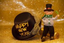 Un pupazzetto accanto a un cappello con scritto "Happy new year"