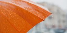 Ombrello arancione aperto che sgocciola acqua in una giornata di pioggia Ombrello arancione aperto che sgocciola acqua in una giornata di pioggia