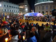 piazza De Ferrari con gente e fontana illuminata di giallo e blu