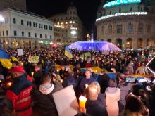 piazza De Ferrari con gente e fontana illuminata di giallo e blu