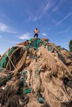 Roberto Guerini della BioDesignFoundation posa soddisfatto in cima a una "montagna" di reti da pesca