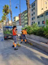 Due giardiniere di Aster al lavoro su una aiuola della passeggiata