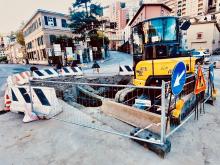 La voragine nell'asfalto delimitata dalle transenne: all'interno della recinzione un grosso escavatore
