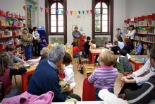 un gruppo di bambini e genitori all'interno di una biblioteca