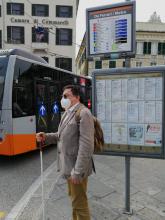 Una persona non vedente alla fermata del bus