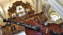 un violino in primo piano, organo di chiesa sullo sfondo